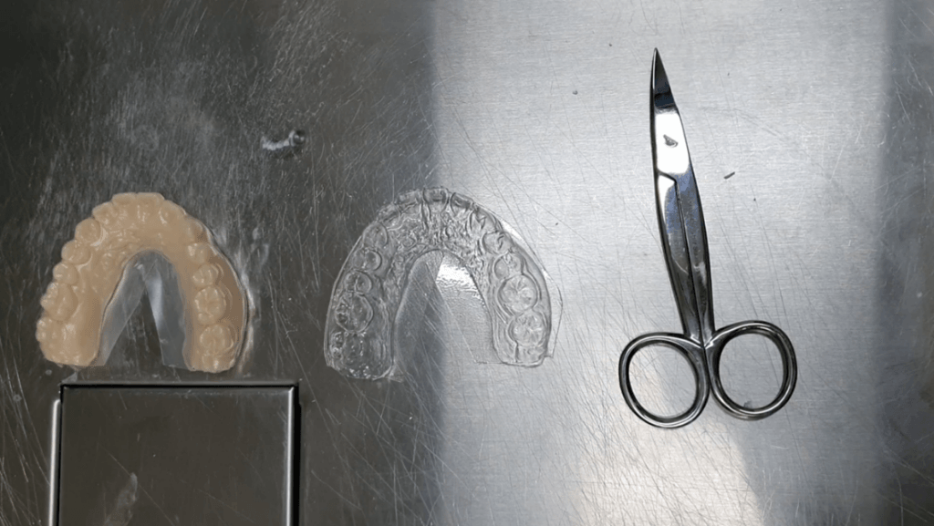Formed device being trimmed with scissors